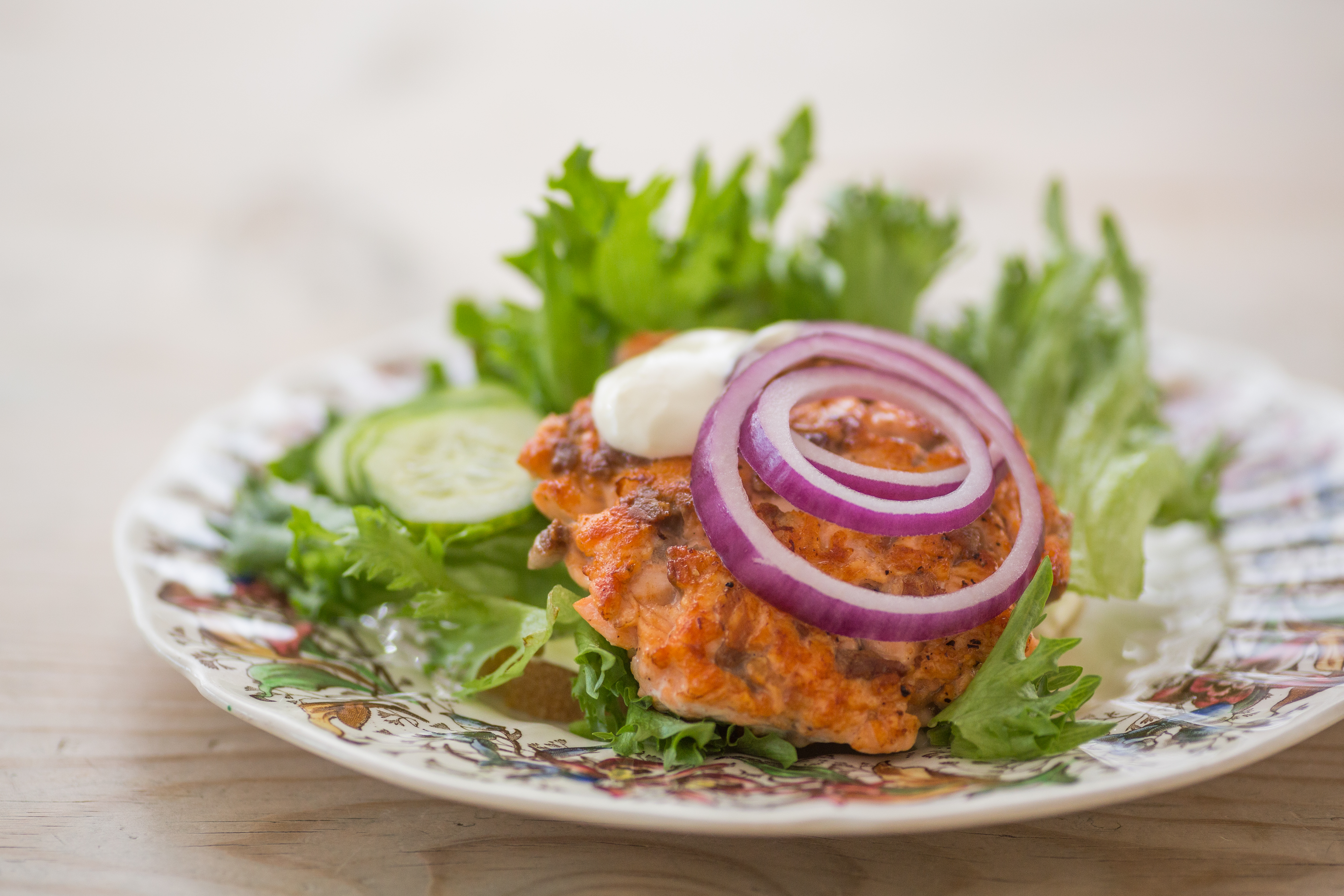 Hjemmelaget fiskeburger med rødløk og rømme